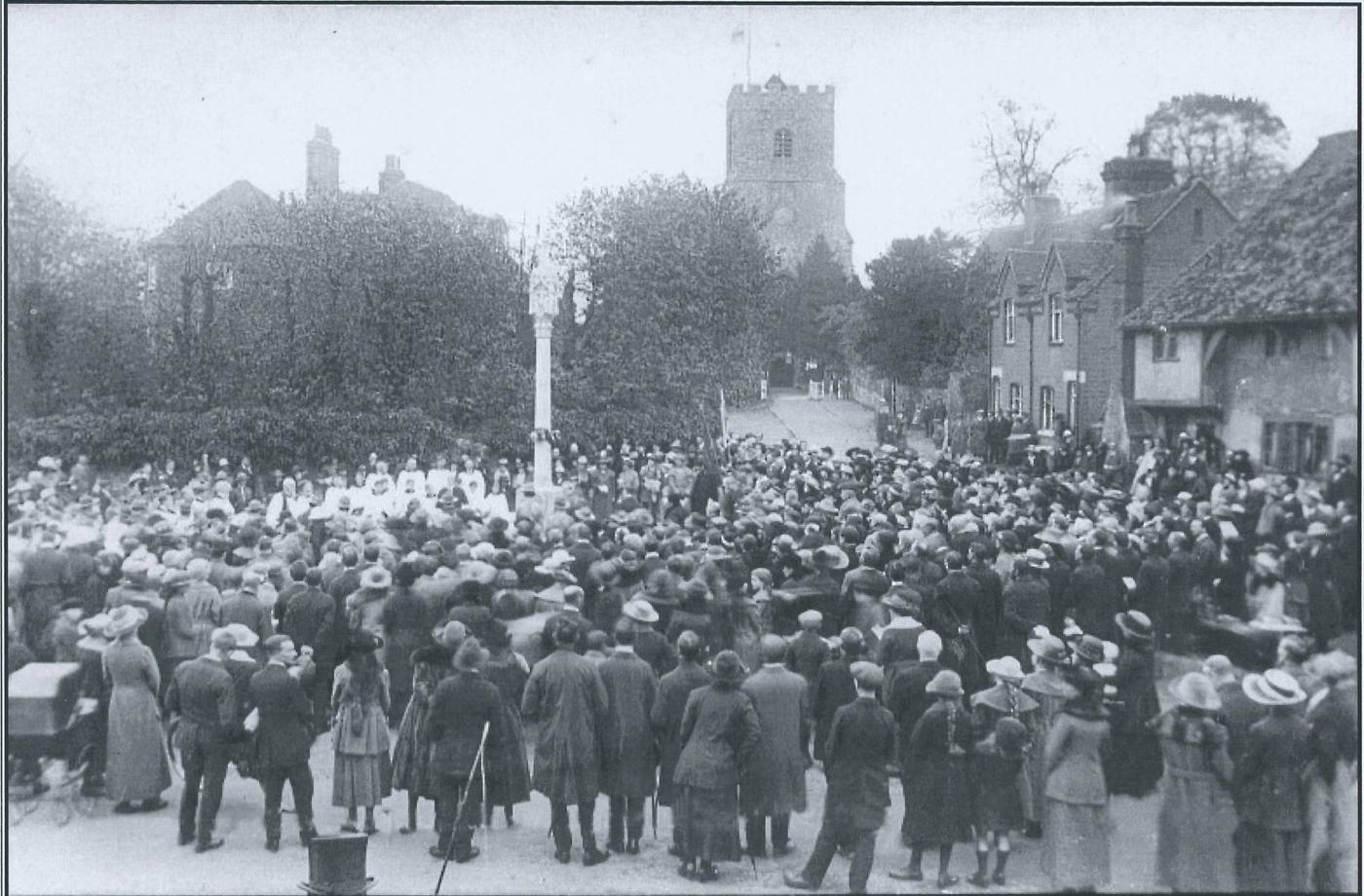 A large crowd gathered around the newly unveiled memorial cross on the green at East Malling, with St James's church tower behind.